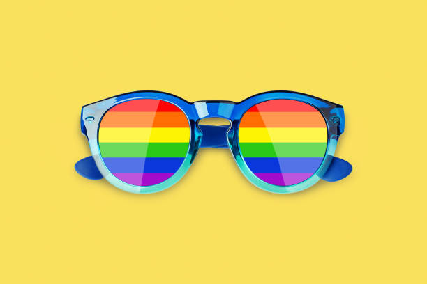 Sunglasses LGBTQ community flag colors yellow background close up, rainbow pattern glasses, LGBT pride people symbol, gay, lesbian etc love sign, human diversity concept, summer holidays fun accessory stock photo