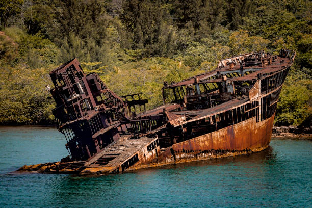 A sunken ship stranded on a beach A sunken ship stranded on a beach is transformed into a rusty shipwreck after an accident capsizing stock pictures, royalty-free photos & images