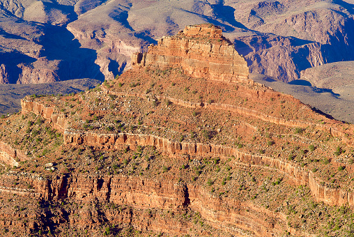 A rock outcrop is bathed in warm sunlight in the Grand Canyon in Grand Canyon National Park.