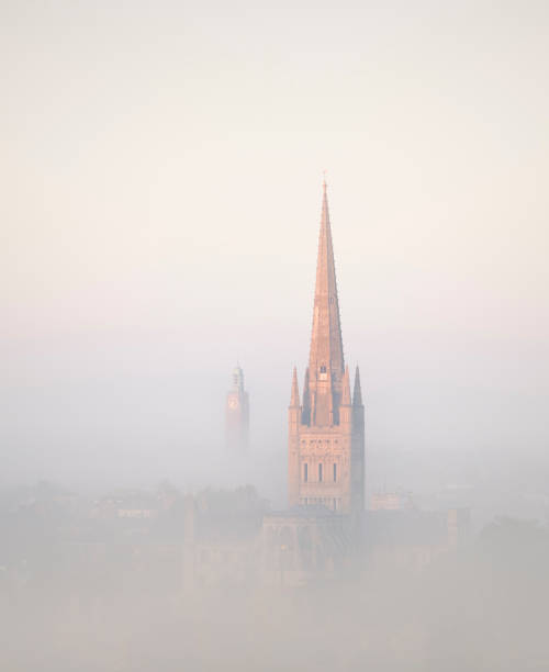 sunlight catching the cathedral on a misty morning over norwich city. - norwich imagens e fotografias de stock