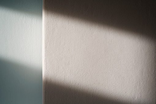 Blank white wall with a light from the window.