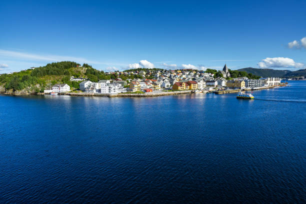 Sunny cityscape of Kristiansund with a ferry boat approaching Nordlandet island, More og Romsdal, Norway stock photo