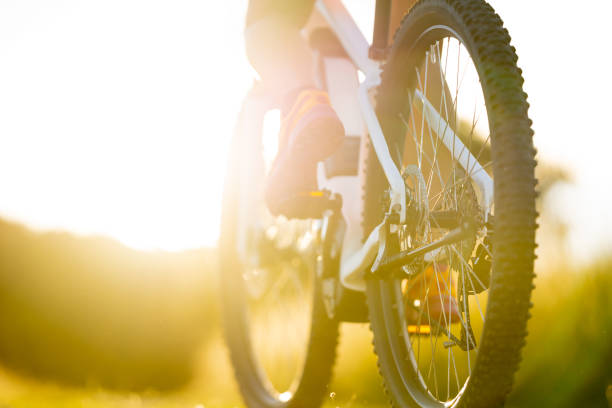 sunny summer mountain bike detail close up part of electric mountainbike sport female legs shoes summer sunny backlight rural landscape tyre electric bicycle stock pictures, royalty-free photos & images