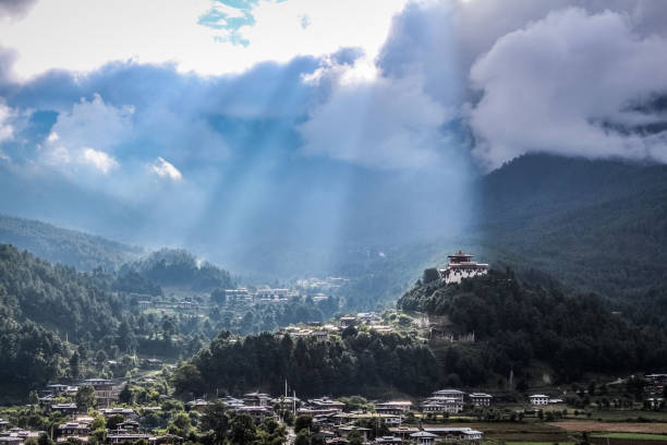 Sunrays leaking from  clouds over peaceful village in Bumthang valley, Bhutan. stock photo