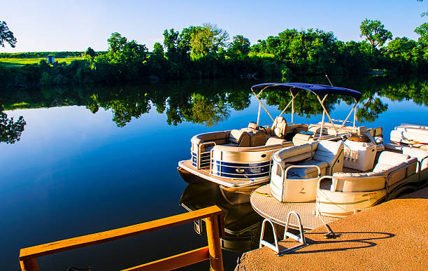 Sunrise on the Lake Pontoon Boat Ready for Summer Sunrise on the Lake Pontoon Boat Ready for Summer. on Lake LBJ the Boats are ready to go , got the shade up , the shadows were long and the golden hour created a golden glow the water on the lake has a perfect mirror image reflecting the symmetric amazing colors of the colorado river  istock images stock pictures, royalty-free photos & images