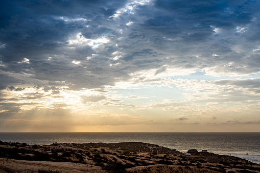 A cloudy morning sunrise above the ocean at the water's edge beach in Mexico.