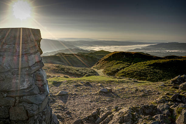 Sunrise over a trig point in English Lake District stock photo