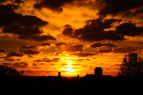 Sunrise over seaside town silhouette stock photo