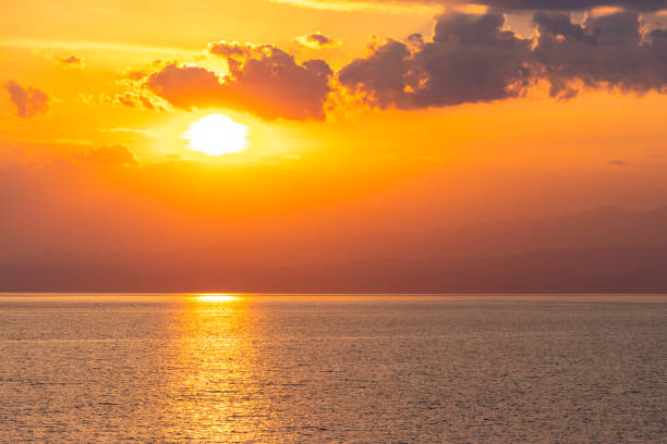 Sunset above calm ocean stock photo