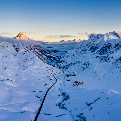 Aerial view of a sunset at a cold evening in winter in the mountains. Photographed at Hochtannbergpass, Vorarlberg, Austria.