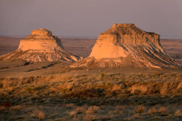 In the evening light, the sedimentary conglomerate of the Pawnee Buttes glow warmly as the wind blows the grass on the Pawnee National Grasslands on the north-eastern plains of Colorado.