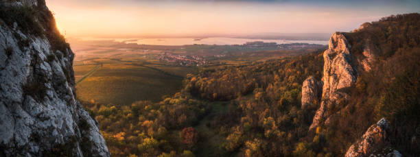 Sunset over Autumn Rocky Landscape Colorful Autumn Sunset over Vineyards and Forest as Seen from Rocky Hill in Palava Protected Area near Mikulov in South Moravia, Czech Republic bohemia czech republic stock pictures, royalty-free photos & images