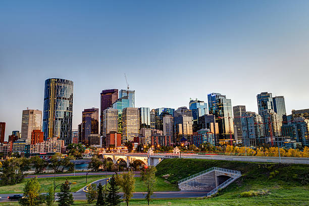 Sunset Over Calgary Downtown Skyline in HDR HDR rendering of Calgary downtown skyline just before sunset showing traffic light trails along Centre Street Bridge across the Bow River and surrounding skyscrapers. calgary stock pictures, royalty-free photos & images