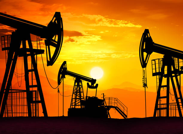 Sunset over drilling rig petroleum pump in the desert stock photo