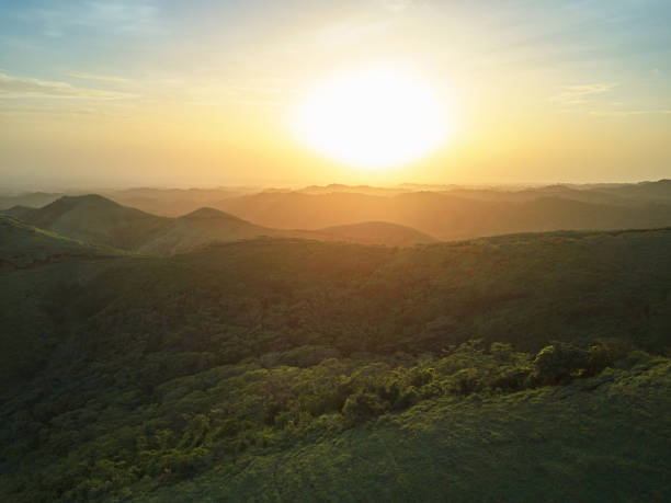 Photo of Sunset over green hills landscape