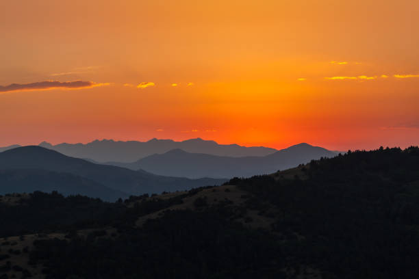 sunset over mountains shade stock photo
