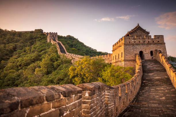Sunset over the Great Wall of China Golden sunlight blankets the Great Wall of China on a moody, cloudy, afternoon near Beijing, China. mutianyu stock pictures, royalty-free photos & images