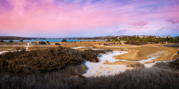 Sunset Seascape over the coastal wilderness and marina under pink pastel-toned romantic clouds after snow stock photo