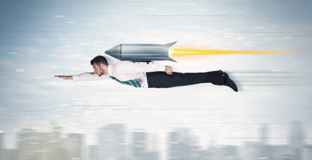 Superhero business man flying with jet pack rocket above the city stock photo
