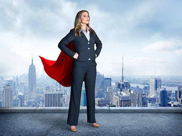 wanita pengusaha superhero dengan pemandangan kota di latar belakang - berdiri posisi fisik potret stok, foto, & gambar bebas royalti