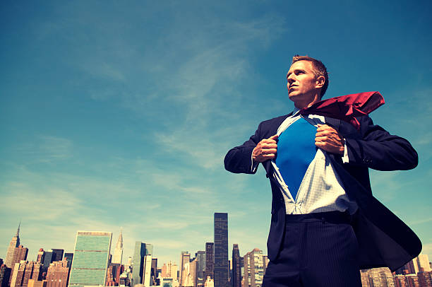 Superhero Young Man Businessman Standing Outdoors Over City Skyline stock photo