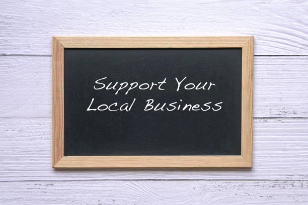 Support Your Local Business, words written on blackboard. Reminder to support and buy goods and services in your community. stock photo