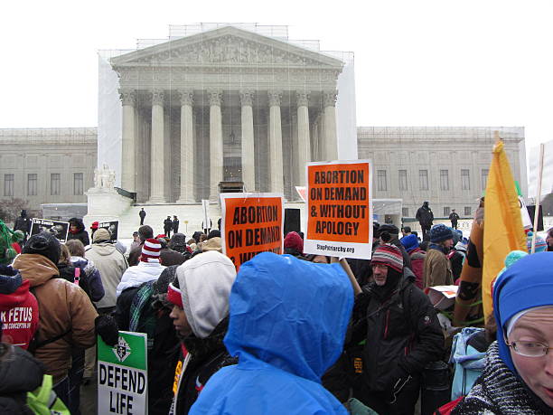 Supreme Court Protest Washington D.C., USA-January 25, 2013:  Pro life protesters protest in front of the Supreme Court in order to turn over the Supreme Court decision Roe Versus Wade on the 40th anniversary date of that decision.  This protest occurs annually drawing large crowds even though the decision to grant a woman the right to choose to have an abortion was made long ago. abortion protest stock pictures, royalty-free photos & images