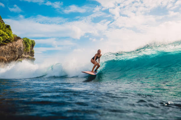 surf girl on surfboard. woman in ocean during surfing. surfer and ocean wave - surf imagens e fotografias de stock