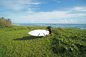 istock Surfboard on scooter moped next to the ocean in green grass. 1332407139