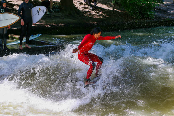 Surfer in the city river called Eisbach at Munich, Germany. Munich is famous for people surfing in urban enviroment stock photo