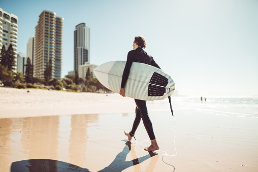 surfer walking in surfers paradise beach in australia