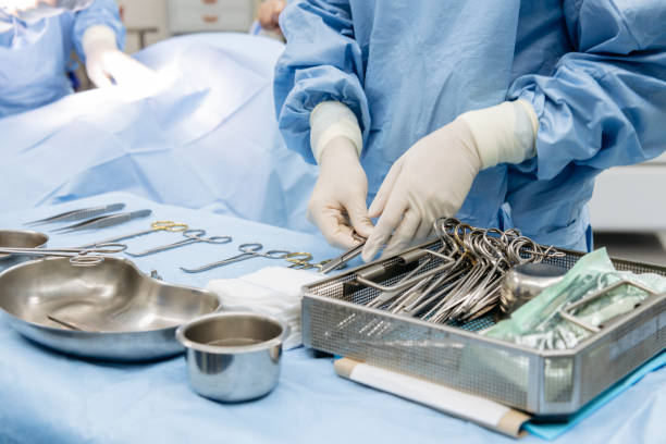 Surgeon carefully sorting medical tools on table Doctor wearing latex gloves, organising surgical scissors in operating room, mid section image technique stock pictures, royalty-free photos & images