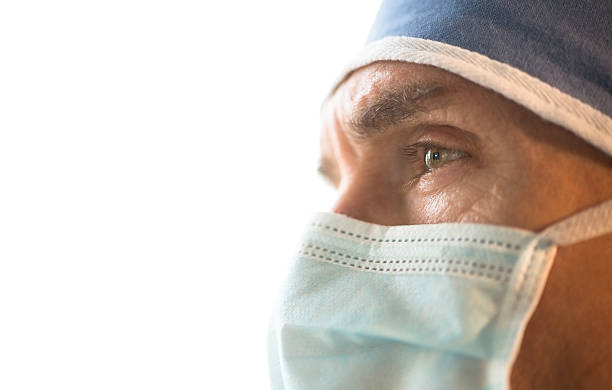 Surgeon Wearing Surgical Mask And Cap Looking Away stock photo
