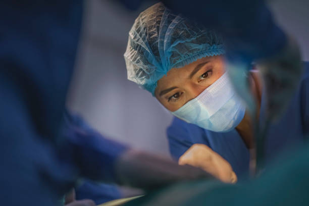 Surgeons performing surgery at hospital stock photo