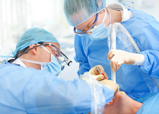 surgeons placing implant stock photo