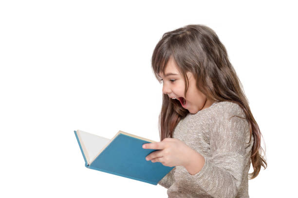 Surprised long haired little girl holding an open book stock photo