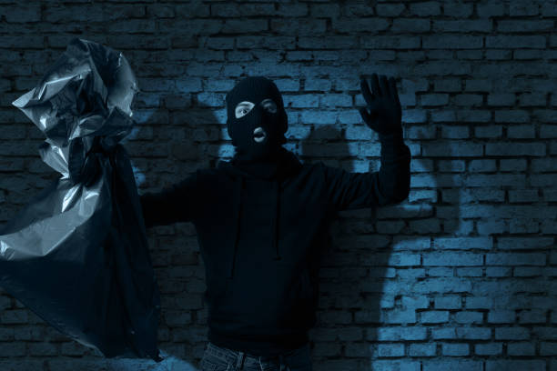surprised thief hold the hands up and get illuminated from the flashlight surprised thief hold the hands up and get illuminated from the flashlight ski mask criminal stock pictures, royalty-free photos & images