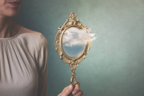 surreal situation of a cloud coming out of a mirror held by a woman surreal situation of a cloud coming out of a mirror held by a woman mirror object photos stock pictures, royalty-free photos & images