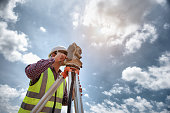istock Surveyor Engineering. Surveyor using telescope at construction site, Surveying for making contour plans are a graphical representation of the lay of the land before startup construction work. 1333165209