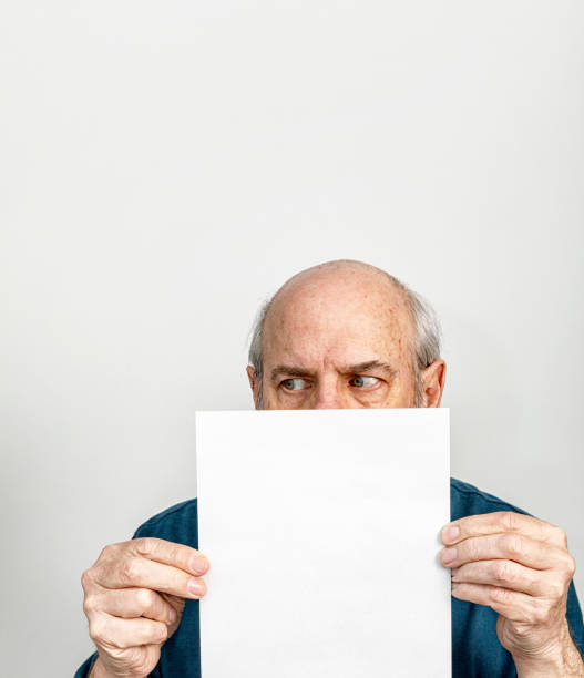 Suspicious Looking Senior Adult Con Man Holding Blank White Card stock photo