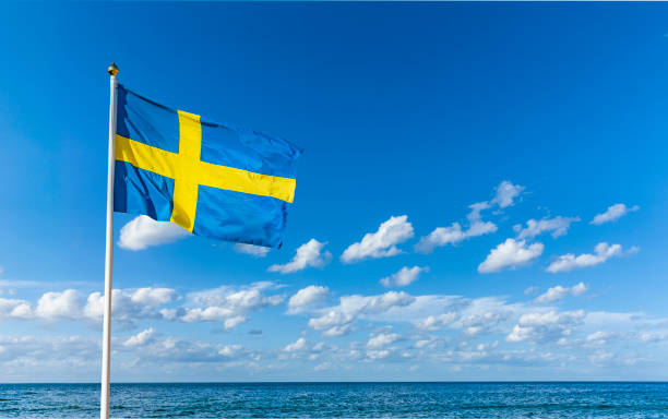Swedish flag in the wind against a blue sky stock photo