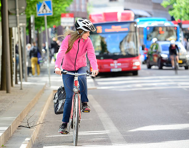 Swedish girl and bicycle in traffic Girl and bicycle, traffic in background swedish girl stock pictures, royalty-free photos & images