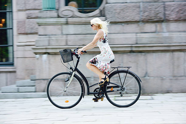 Swedish girl in summer dress on bicycle in city Swedish girl in summer dress on bicycle in city swedish girl stock pictures, royalty-free photos & images