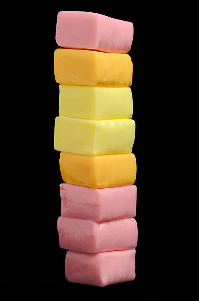 Sweet Juicy Fruit Chew Candies A stack of sweet juicy fruit chew candies against a black background chewy stock pictures, royalty-free photos & images