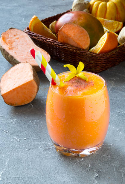 Sweet Potato Smoothie coctail with orange, mango, pumpkin. Vitamin, healthy food concept. Sweet Potato Smoothie with orange, mango, pumpkin in a box on a grey background. Gluten-free and healthy food concept. Copy space for text orange smoothie stock pictures, royalty-free photos & images