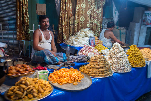 Sweet Shop in a festival market in India. Chandannagar, West Bengal, India - November 18, 2018: Sweet Shop seller selling variety of sweets on a the festive occasion of Jagdhatri puja. bengali sweets stock pictures, royalty-free photos & images