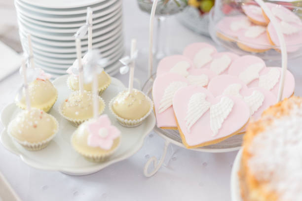 Sweet table at Christening or First Communion party. Vanilla cookies with angel wings decor communion photos stock pictures, royalty-free photos & images