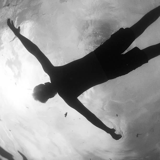 Swimmer from below Swimmer floating on his back.  floating on water photos stock pictures, royalty-free photos & images