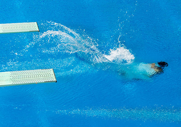 swimmer jump submerged in water with two trampoline stock photo