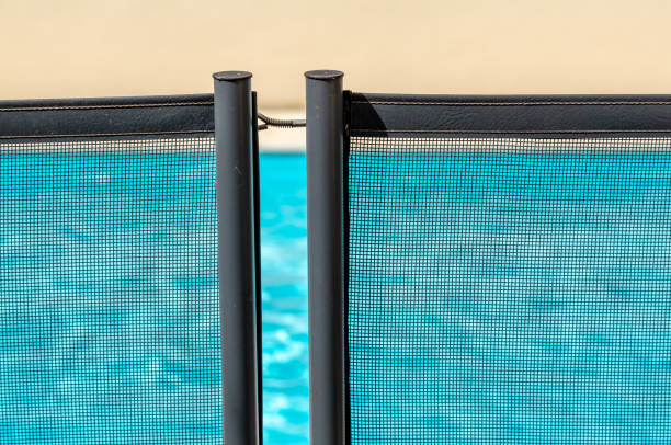 Swimming Pool through a mandatory safety net on the edges of a private psicine View of a pool through a mandatory safety net on the edges of a private psicine rusty fence stock pictures, royalty-free photos & images